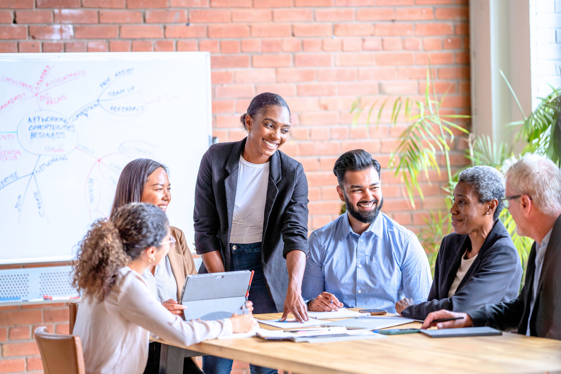 Diverse group of professionals in a business meeting, discussing small business growth and funding options like SBA 504, SBA 7(a), and SSBCI loans—empowering entrepreneurs through strategic lending solutions.