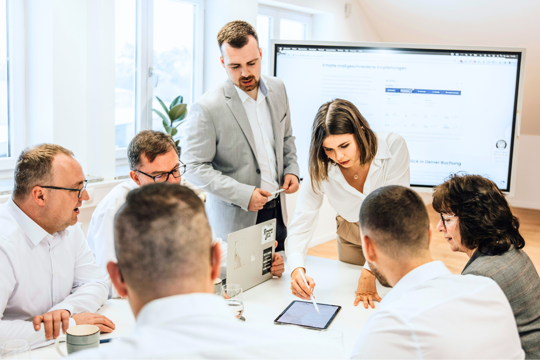 Business team reviewing financial data and loan solutions on a digital dashboard, collaborating on SBA 7(a), SBA 504, and SSBCI funding options to support small business financing and growth strategies.